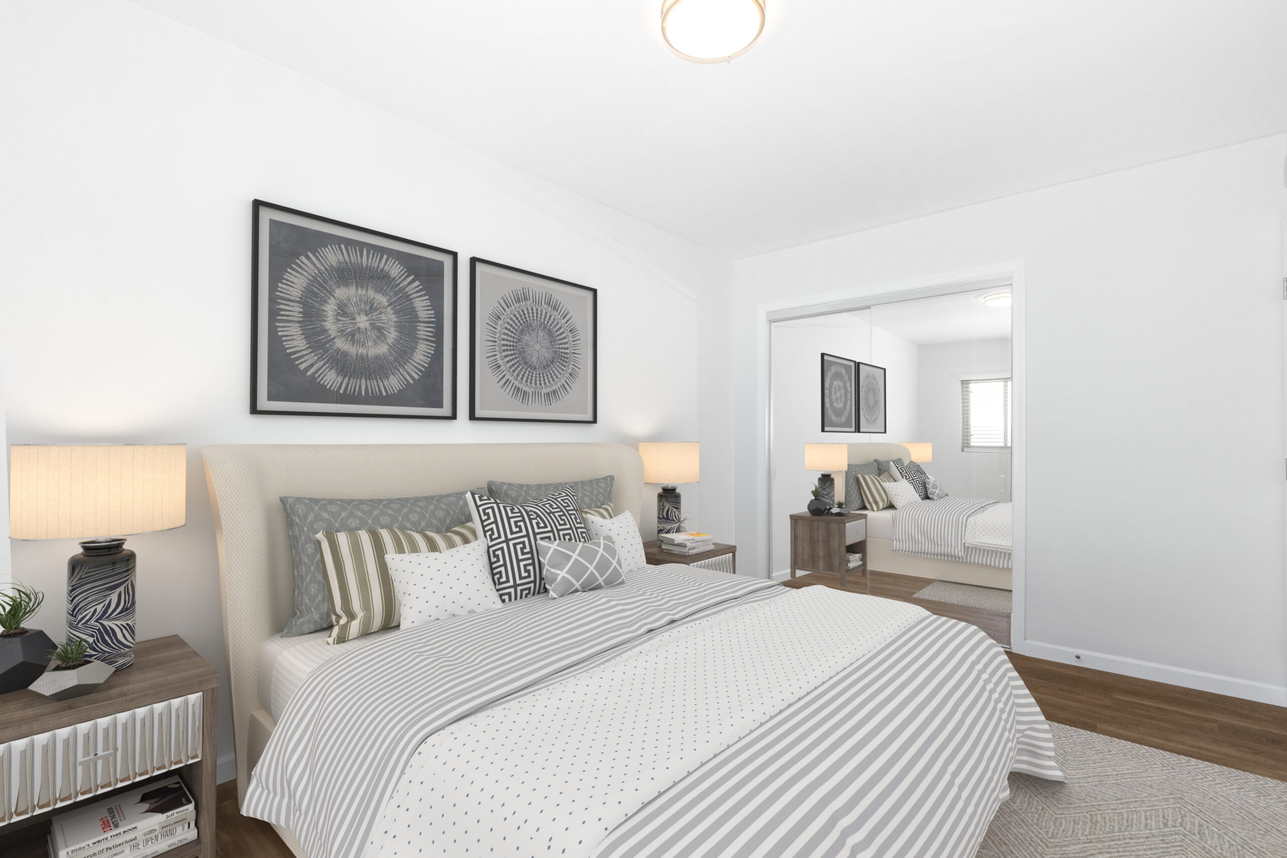 Home Comfortable bedroom in a renovated Imperial Beach bungalow rental with upholstered bed, decorative artwork, and mirrored wardrobe doors.