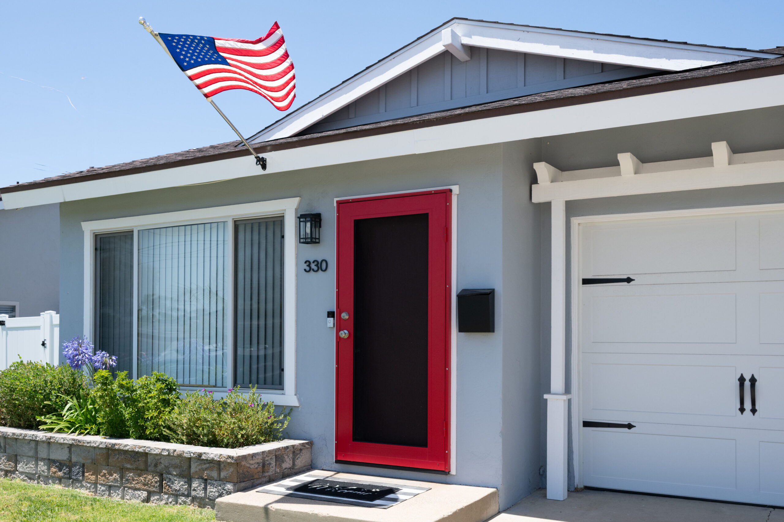 Gallery Renovated Imperial Beach duplex rental with landscaped front yard, red entry door, and attached garage.