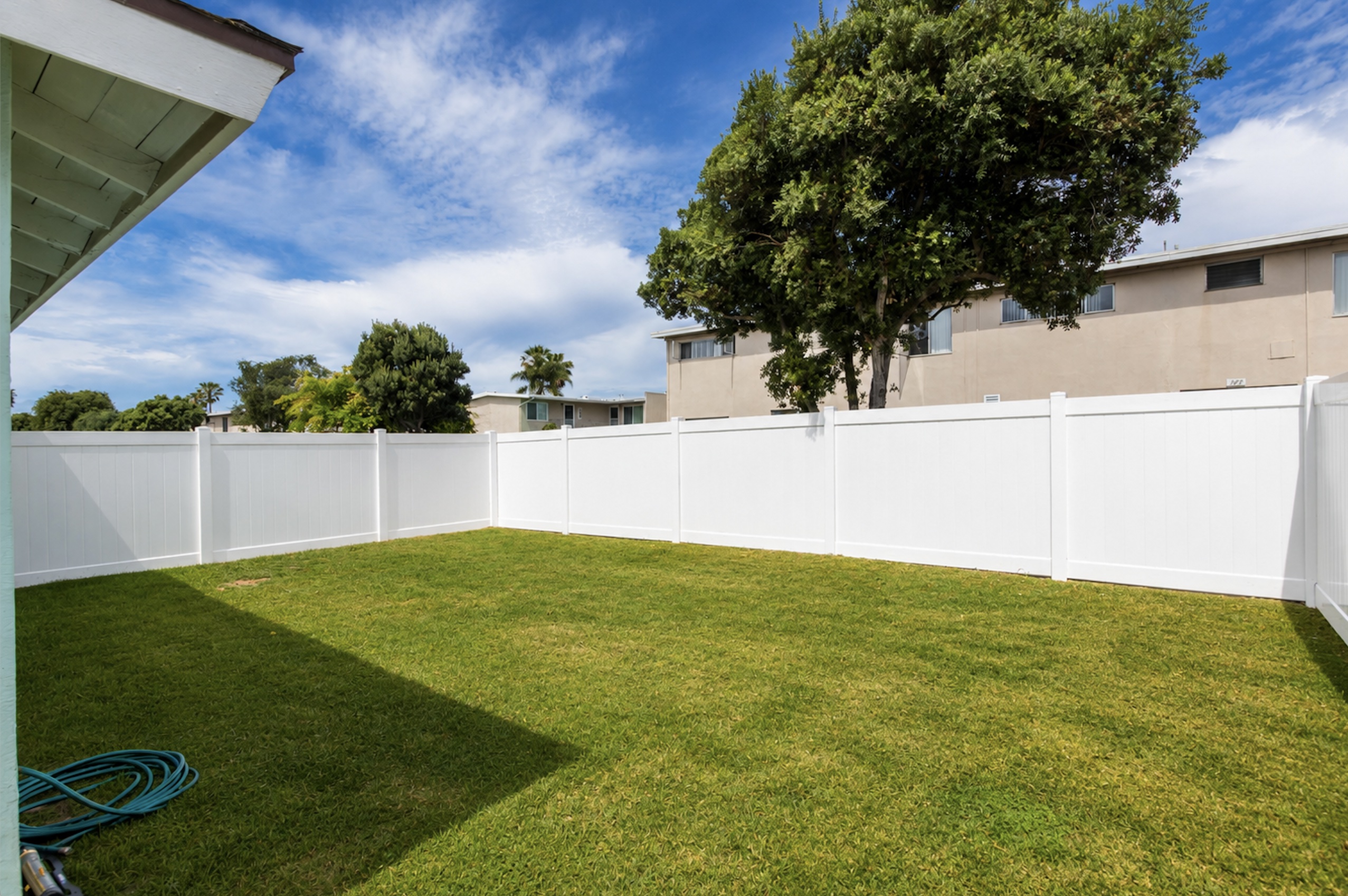 Gallery Private fenced backyard with green lawn at a renovated Imperial Beach duplex rental.