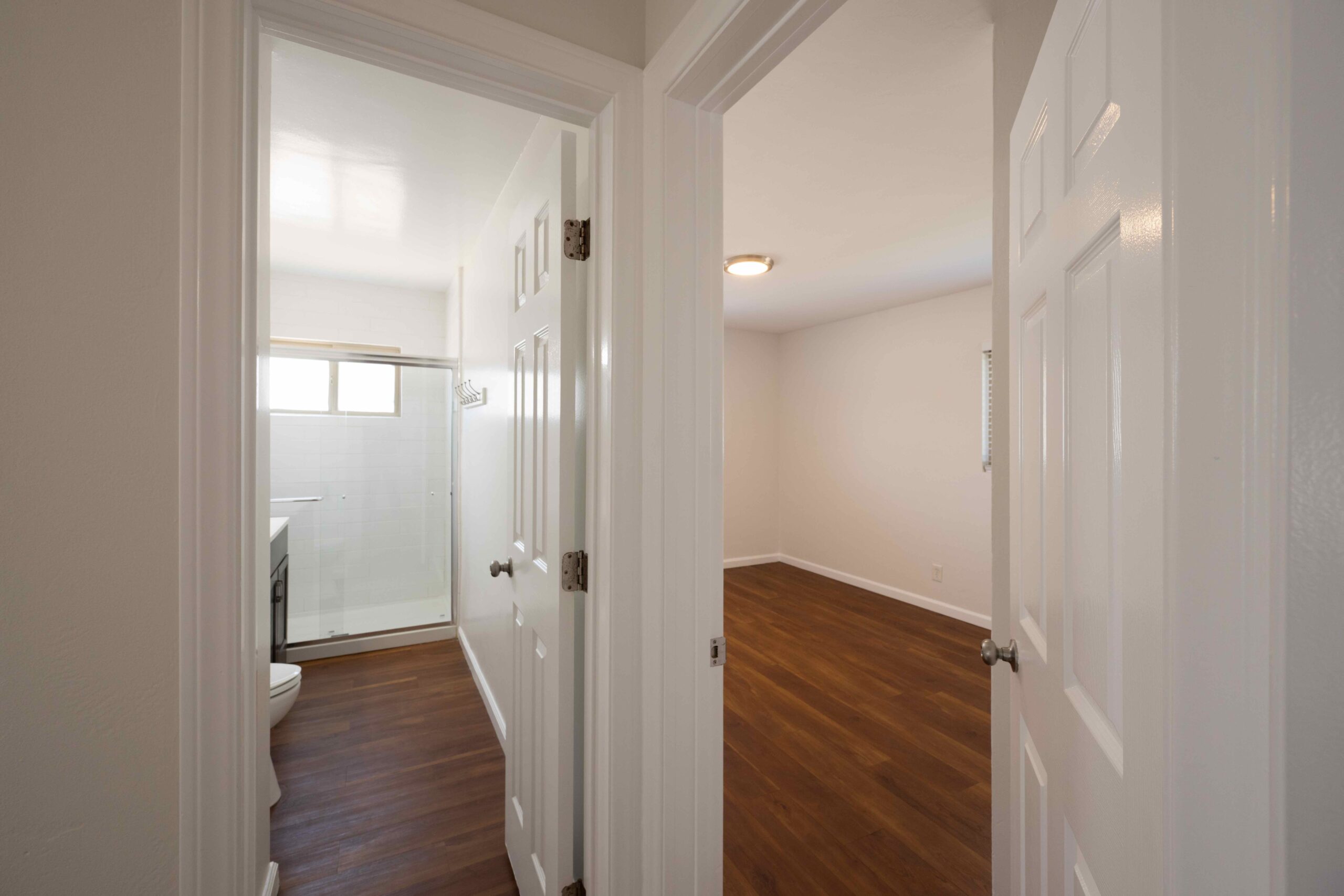 Gallery View from the hallway into the renovated bathroom, showing the tiled shower and vanity.