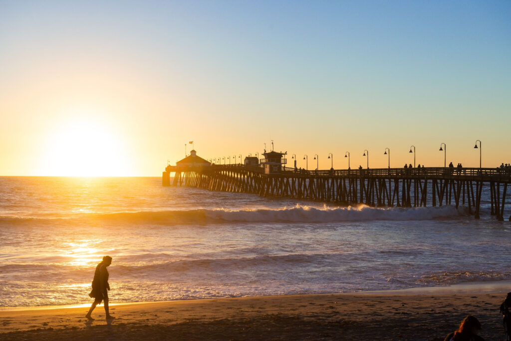 Home Imperial Beach sunset with waves, sandy shoreline, and Imperial Beach Pier along the Pacific coast.