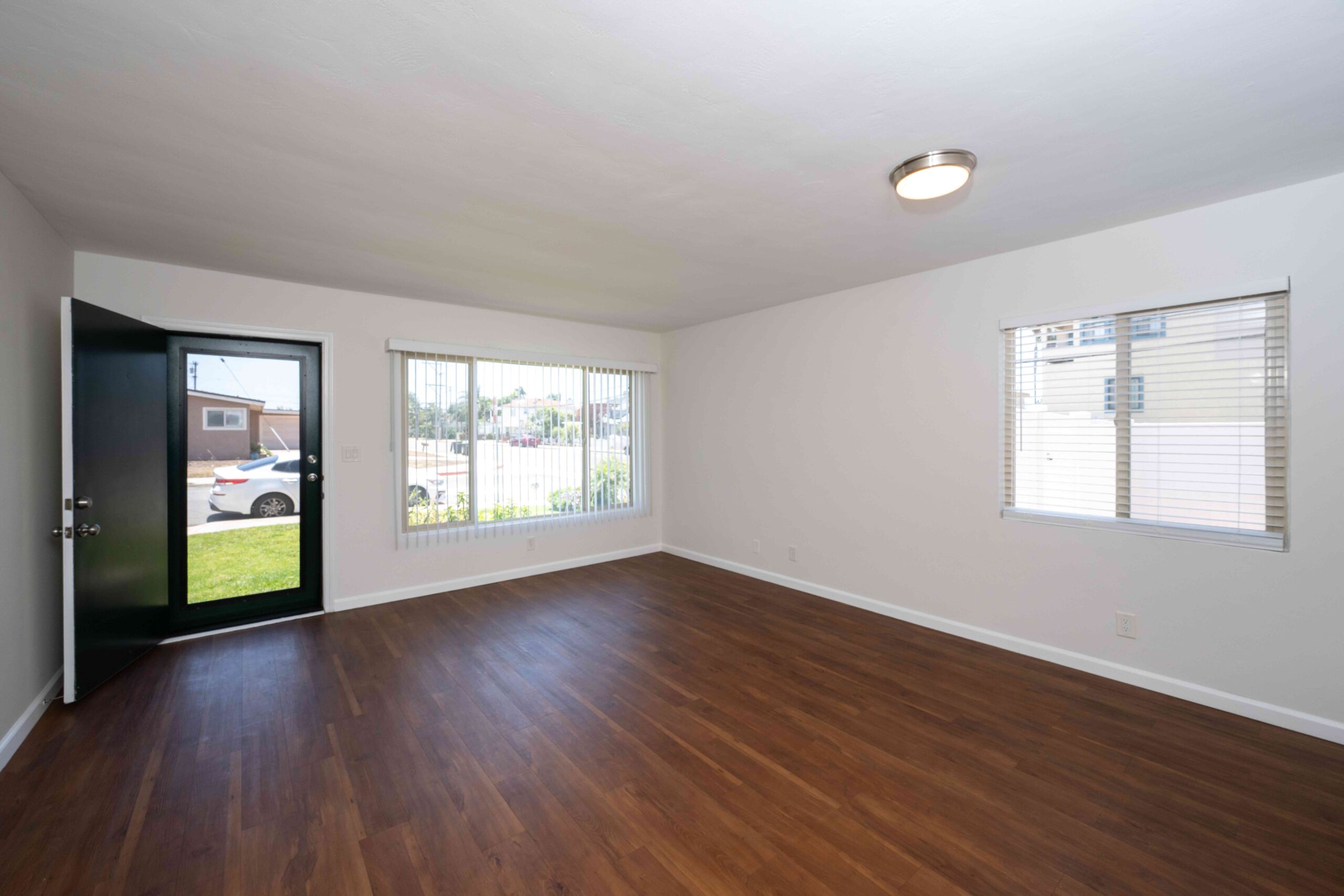 Gallery Spacious two-bedroom residence living room with wood-look flooring and large windows.