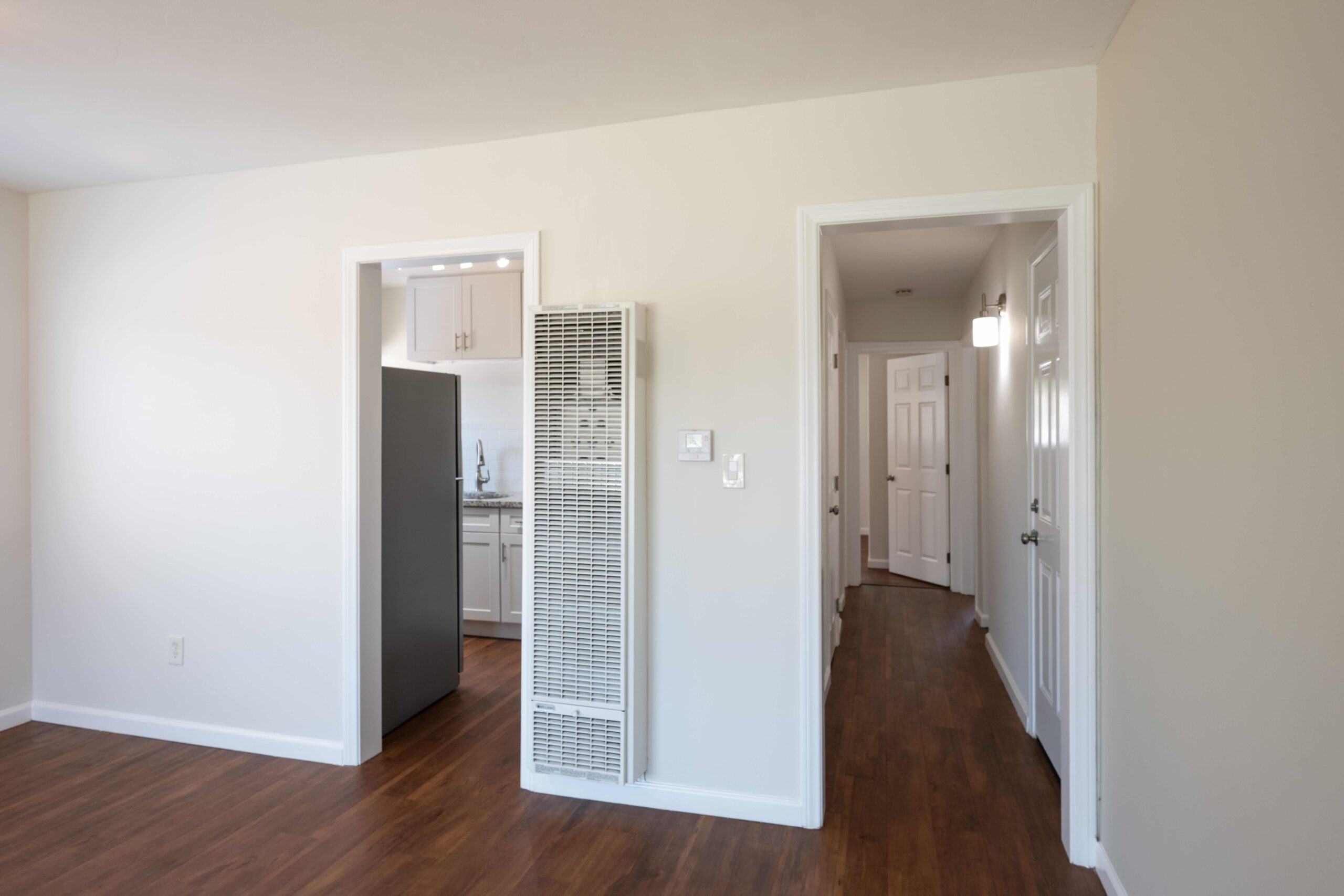 Gallery Living room entrance with wood-look flooring, hallway, and built-in heating unit.